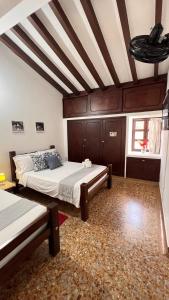 a bedroom with two beds and a wooden ceiling at GREEN DOOR HOSTEL BOUTIQUE in San Gil