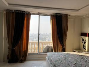 a bedroom with a bed and a large window at stunning studio apartment in Rāmkot