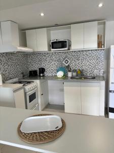 a kitchen with white appliances and a white counter top at Departamento 66 - cochera opcional - in La Plata +10 photos