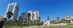 a statue in a park in a city with tall buildings at Green Apartment in Durrës +38 photos