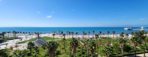 a view of a beach with palm trees and the ocean at Green Apartment in Durrës