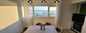 a dining room table with a vase of flowers on it at Green Apartment in Durrës