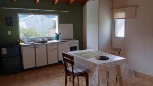 a kitchen with a table and a table and chairs at Alta Montaña Apart in El Chalten