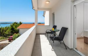 a balcony with chairs and a table and a view of the ocean at 2 Bedroom Nice Apartment In Banjol in Banjol