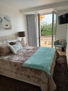 a bedroom with a large bed and a large window at T1 Praia Areia Branca in Lourinhã +29 photos
