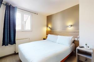 a bedroom with a white bed and a window at Hôtel de Ménilmontant in Paris