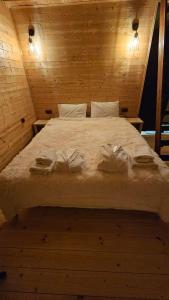 a bed in a wooden room with towels on it at mood villa kazbegi in Kazbegi