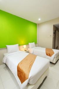 En eller flere senge i et værelse på Rivisha Hotel