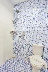 a bathroom with a toilet and a blue tiled wall at Rivisha Hotel in Yogyakarta