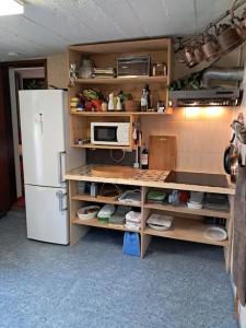 a kitchen with a refrigerator and a microwave at Casa Vintage Seixal Madeira in Seixal