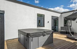 eine Terrasse mit einem Grill auf einer Holzterrasse in der Unterkunft Nice Home In Ebeltoft With Sauna in Ebeltoft + 28 Fotos