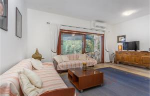 a living room with a couch and a table at Nice Apartment In Njivice With Wifi in Njivice