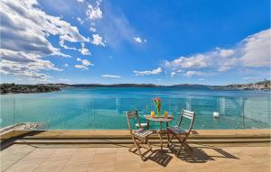 トロギールにあるAmazing Home In Trogir With Saunaのテーブルと椅子、水辺の景色を望むバルコニー