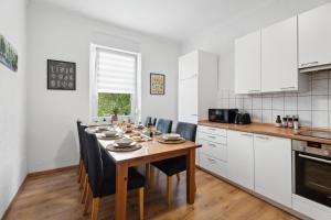 une cuisine avec une table en bois et des chaises ainsi qu'une salle à manger dans l'établissement Neue und helle 2 Zimmer Wohnung, nähe Veltins Arena, Home Office, kostenlose Parkplätze, à Gelsenkirchen