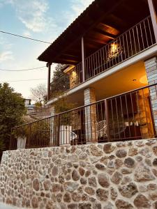 a house with a stone wall in front of it at Rocks Republic in Kalabaka