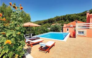 a swimming pool with two chairs and an umbrella at Holiday Home Smokvica Smokvica in Smokvica
