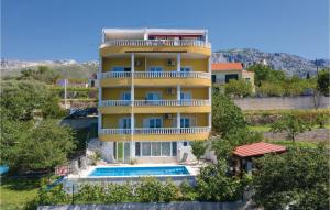 ein gelbes Gebäude mit einem Swimmingpool davor in der Unterkunft Amazing Apartment In Zrnovnica in Korešnica