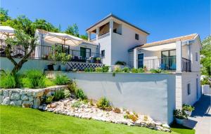a house with a retaining wall and a garden at Four-Bedroom Holiday Home In Zaton in Zaton