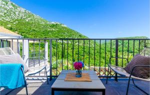a vase of flowers on a table on a balcony at Four-Bedroom Holiday Home In Zaton in Zaton