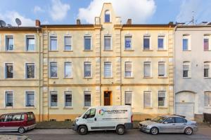une camionnette blanche garée devant un immeuble dans l'établissement Neue und helle 2 Zimmer Wohnung, nähe Veltins Arena, Home Office, kostenlose Parkplätze, à Gelsenkirchen