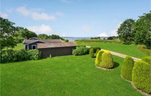 a garden with bushes and a house in the background at Amazing Home In Egernsund With Wifi in Egernsund