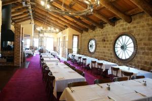 une salle à manger avec des tables et des chaises blanches ainsi qu'une horloge dans l'établissement Mahogany Park, à Cranbourne