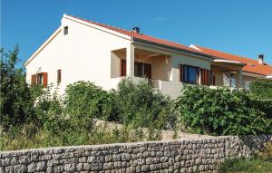 a white house behind a stone wall at One-Bedroom Apartment In Maslenica in Maslenica