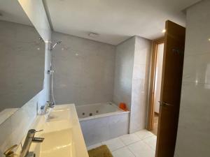 a bathroom with a sink and a bath tub at Luxurious and modern 2BR with View and Pool in Beni Brour +13 photos