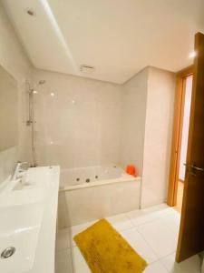 Beni BrourにあるLuxurious and modern 2BR with View and Poolの浴槽と洗面台のある白いバスルーム