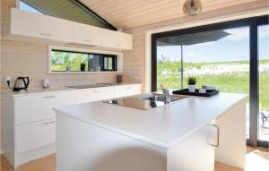 a kitchen with white cabinets and a large window at Three-Bedroom Holiday Home In Grenaa in Grenå