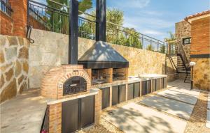 アレーリャにあるStunning Home In Alella With Wifiの柵のあるパティオにあるレンガ造りのオーブン