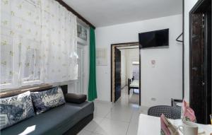 a living room with a couch and a television at 1 Bedroom Stunning Apartment In Krk in Krk