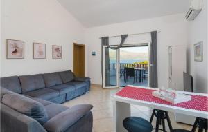 a living room with a couch and a table at Gorgeous Home In Postira in Postira