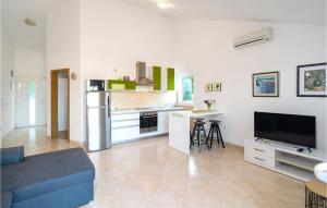 a kitchen and living room with a blue couch at Gorgeous Home In Postira in Postira