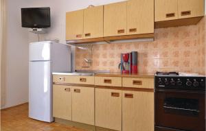 a kitchen with a white refrigerator and a stove at Apartment Alojzija Stepinca Ii in Starigrad-Paklenica