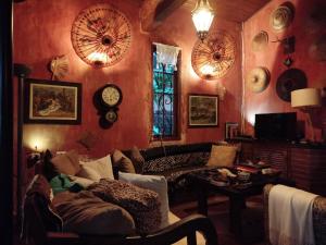 a living room with a couch and a clock on the wall at Vila Santa Rosa in Ilhabela