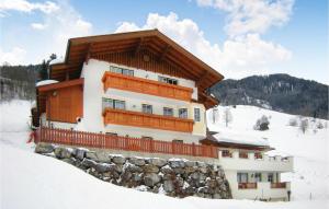 un edificio en una pendiente cubierta de nieve con en Haus Lindorfer-Ferienwohnung, en Grossarl