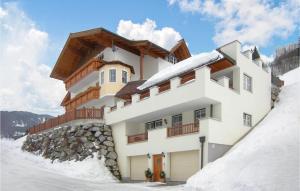 un edificio en la cima de una montaña cubierta de nieve en Haus Lindorfer-Ferienwohnung, en Grossarl