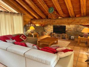 a living room with a white couch and a tv at Le Refuge - 5 bedroom chalet with sauna in Sainte-Foy-Tarentaise