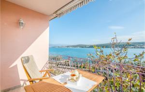 stół i krzesła na balkonie z widokiem na wodę w obiekcie Cozy Apartment In Cizici w mieście Čižići