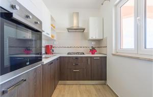 kuchnia z drewnianymi szafkami i oknem w obiekcie Cozy Home In Vodnjan With Wifi w mieście Vodnjan