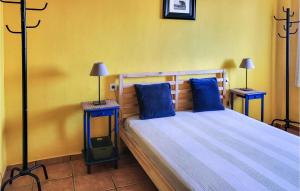 ein Schlafzimmer mit einem Bett mit blauen Kissen und 2 Tischen in der Unterkunft Stunning Apartment In El Campello in El Campello