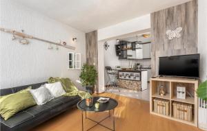 a living room with a black couch and a kitchen at Cozy Apartment In Vrbnik With Wifi in Vrbnik