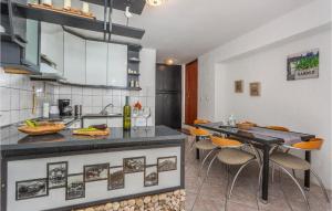 a kitchen with a counter and some chairs in it at Cozy Apartment In Vrbnik With Wifi in Vrbnik