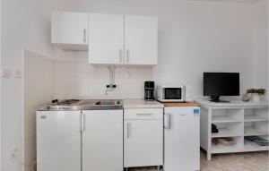 a white kitchen with a sink and a microwave at 1 Bedroom Amazing Apartment In Krk in Krk