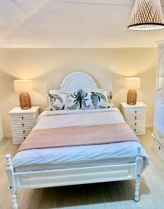 Un dormitorio con una cama blanca con dos mesitas de noche. en Sebastian's Apartment, en São Vicente