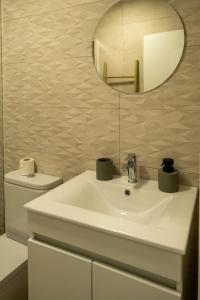 Un baño con un lavabo blanco y un espejo. en Casa do Torres, en Évora