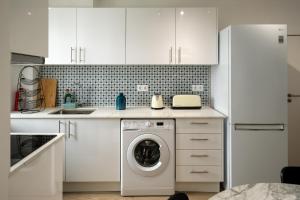 una cocina blanca con lavadora. en Casa do Torres, en Évora 3 fotos más