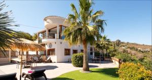 una palmera frente a una casa blanca en Exceptional Costa del Sol Villa Apartment BALCON DE TORROX for 4 Heated pool Amazing views & quality, en Torrox