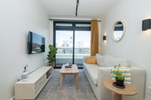 un soggiorno con un divano e una TV di Stylish 1-Full Bedroom Apartment with a separate Living Room, Workspace and Kitchen close to the beach and V&A in Cape Town a Città del Capo